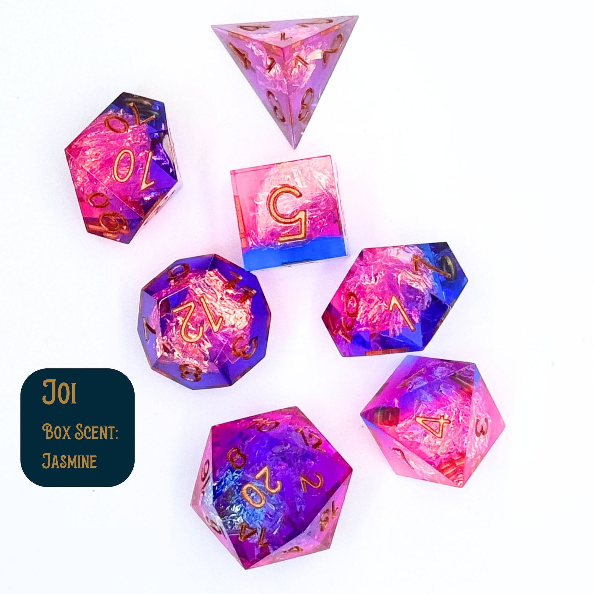 Joi dice collection of seven polyhedral dice with a pint blue tint and cellophane in the center. Shown on a white background